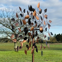 Amboise, éolienne décorative en métal cuivré dans un jardin vue de coté